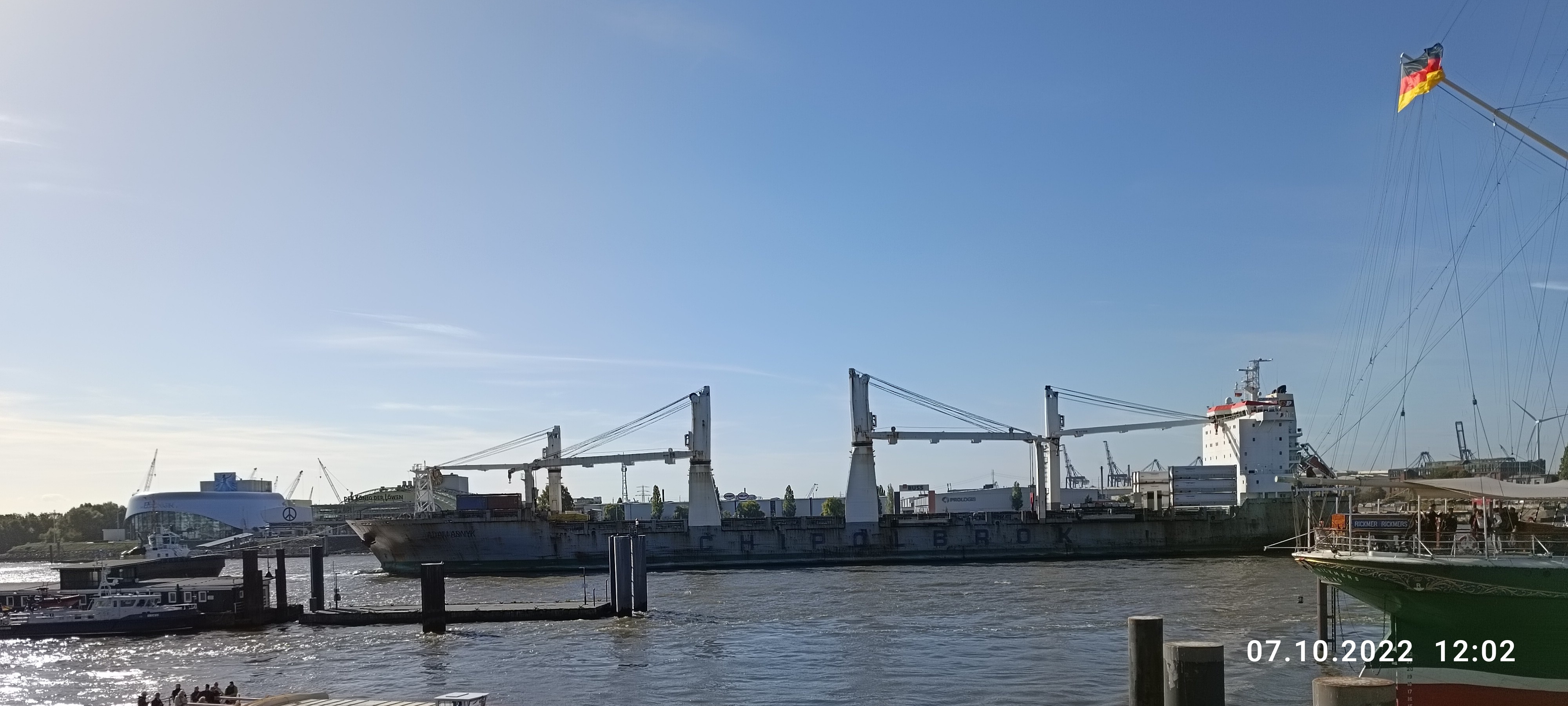 Hafencity - ein großes Containerschiff wird durch die Hafencity geschleppt