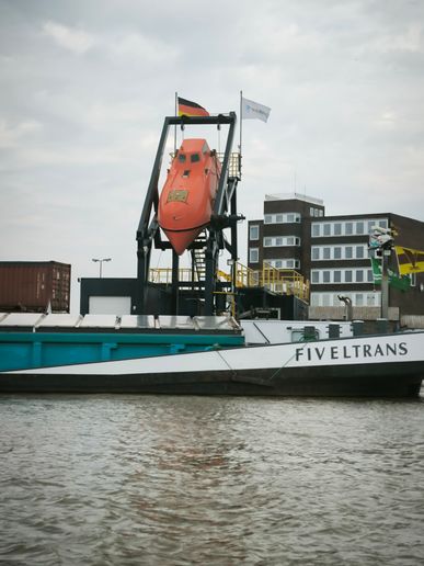 ein Schiff mit einem integrierten Rettungsboot welches sich senkrecht ins Wasser bewegt